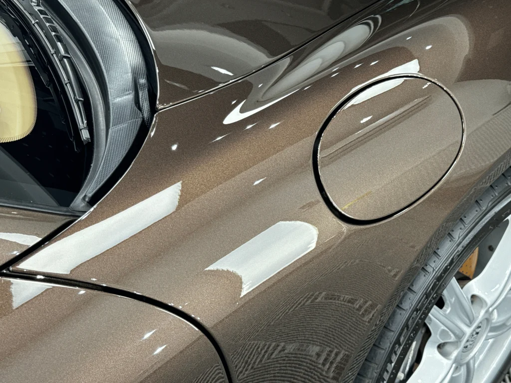 Aripa față cu capacul rezervorului la un Porsche Boxster maro, după aplicarea foliei PPF