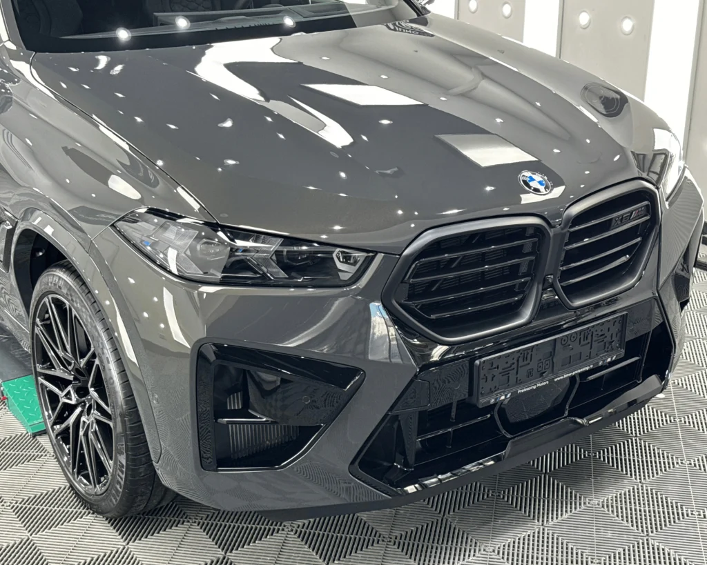 Capota, grila și bara față ale unui BMW X6M gri după aplicarea foliei PPF