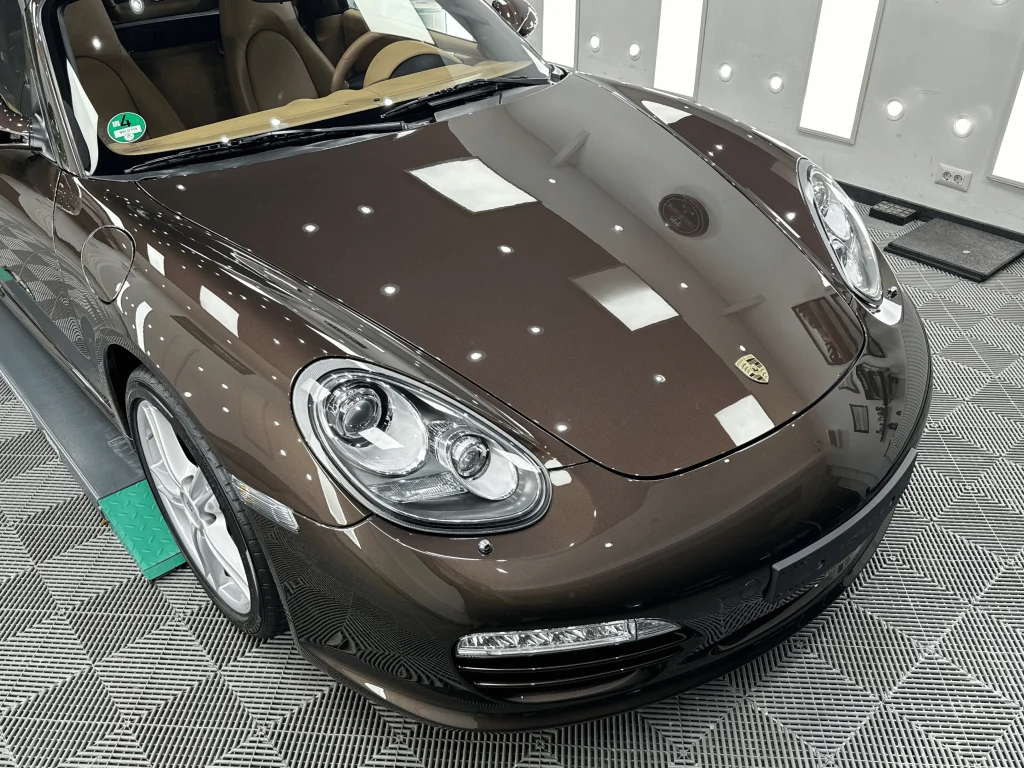 Fața unui Porsche Boxster maro după aplicarea foliei PPF pe capotă, faruri și aripi