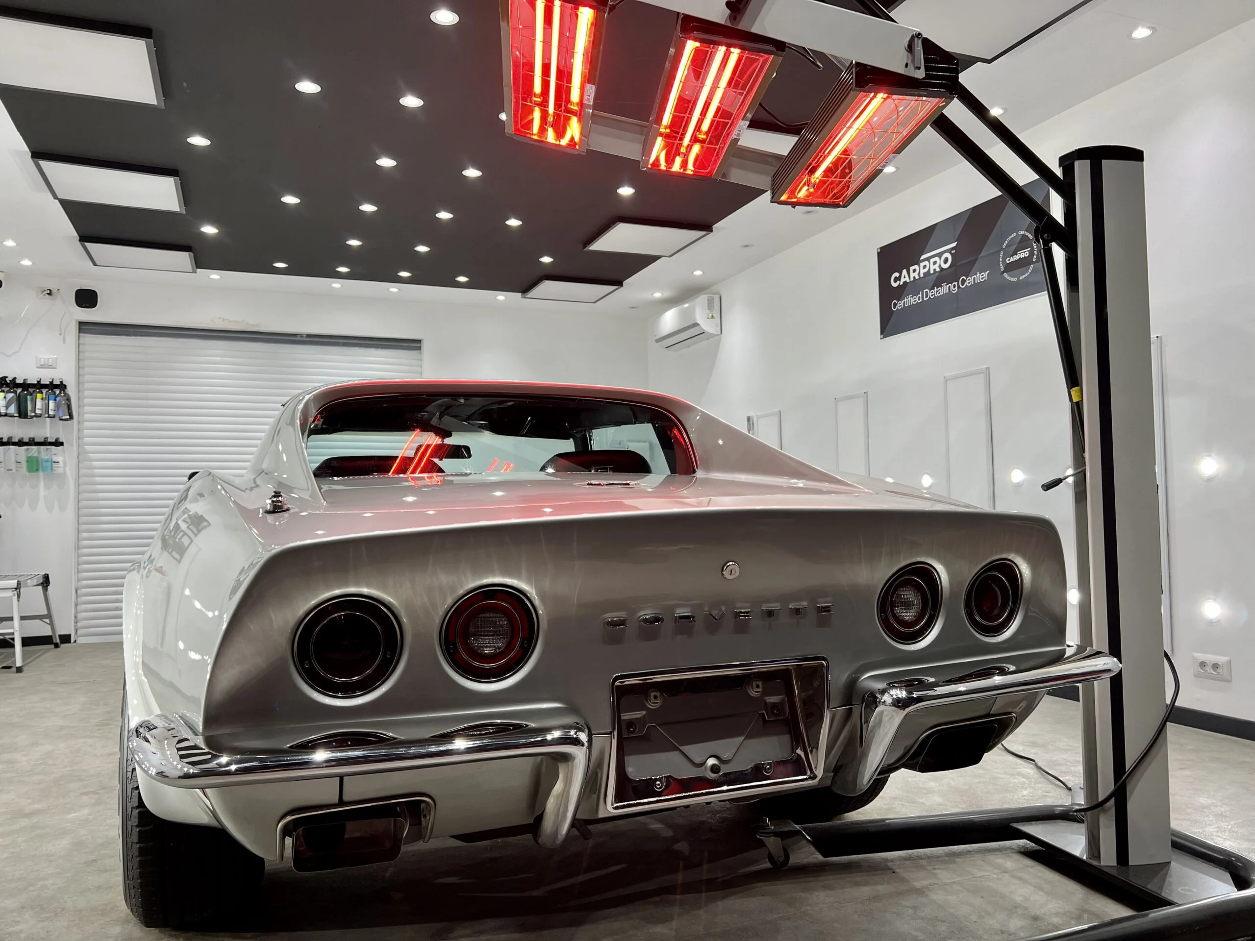 Chevrolet Corvette argintiu sub lămpile cu infraroșu din atelierul Detailing Caffe