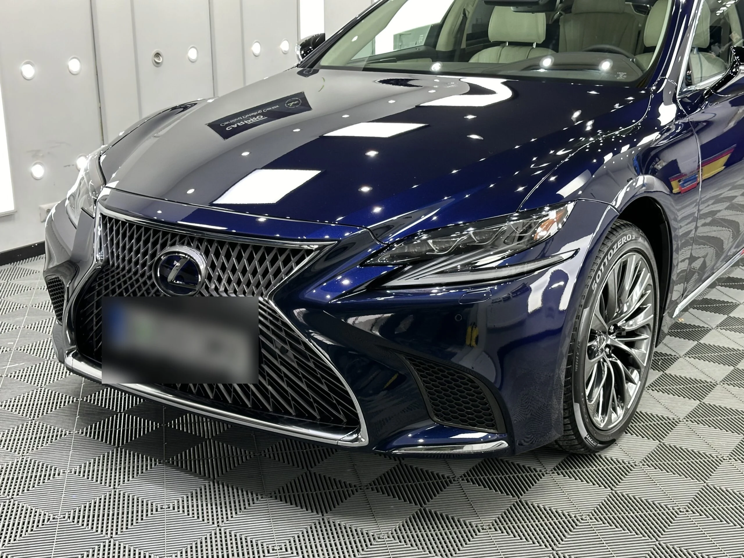 Fața unui Lexus LS albastru închis, cu grila și farul, după protecția ceramică